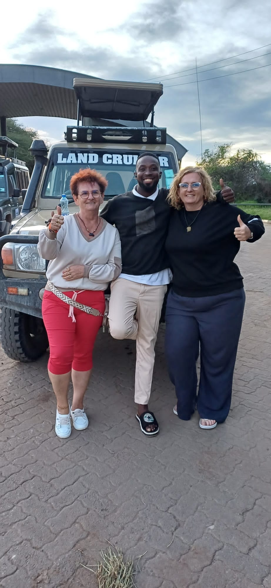 Guests and guide beside the Land Cruiser at golden hour