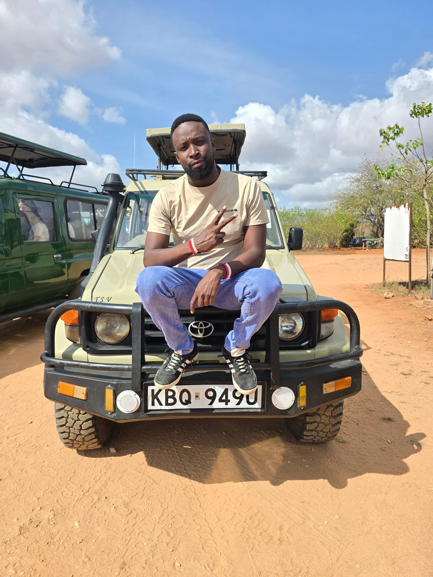 Guide by the safari vehicle on a red dirt road, Tsavo